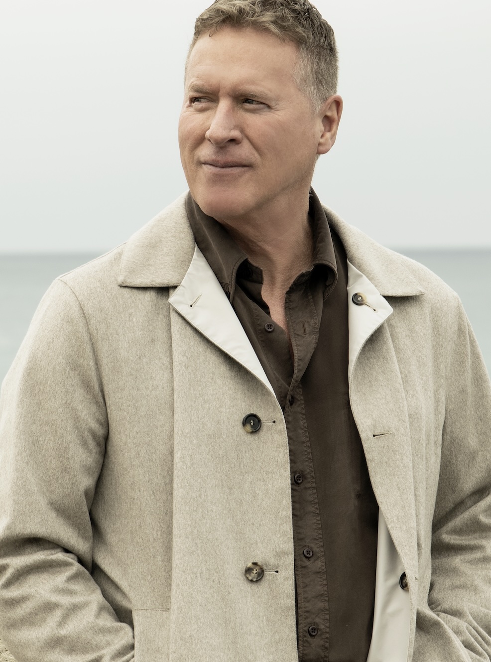 A close portrait of Ken Laird seated by the water.